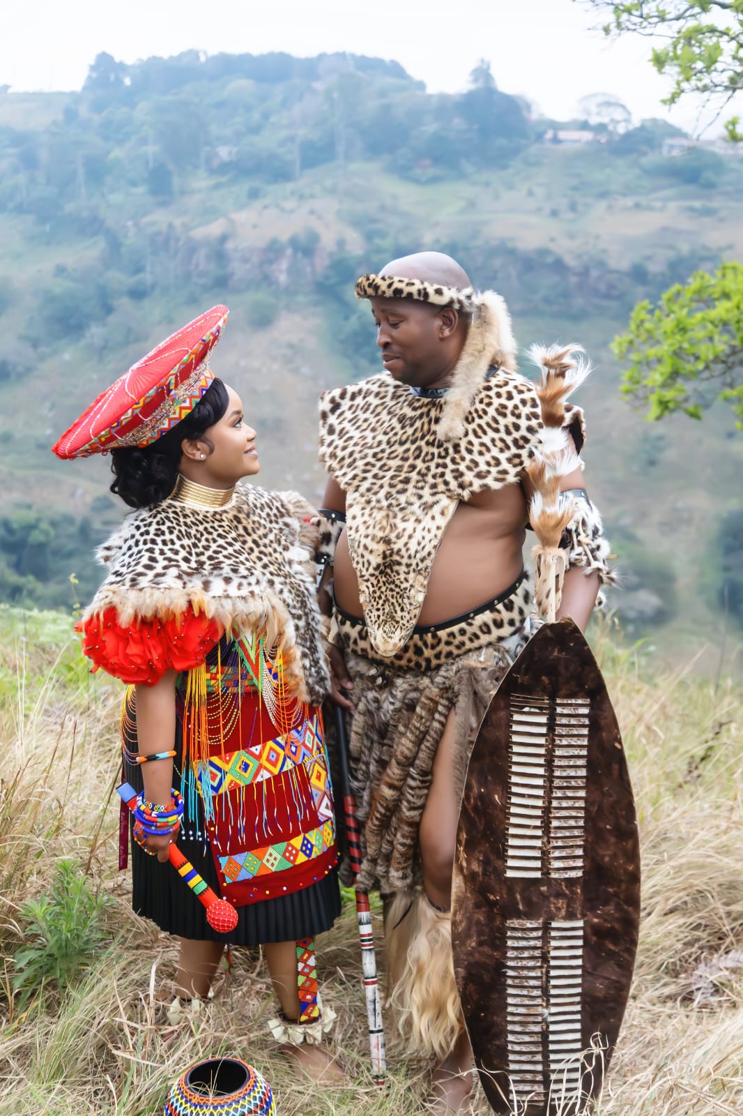 The couple looking at one another in full traditional dress